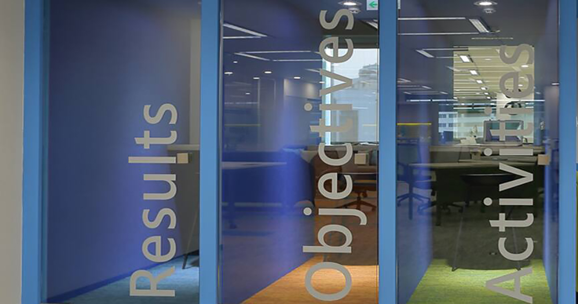 Results, Objectives and  Activities written on three different glass door of a corporate office